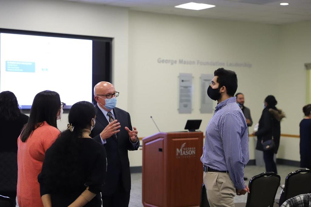 Image of HAP students and alumni speaking to the president of Inova Health System